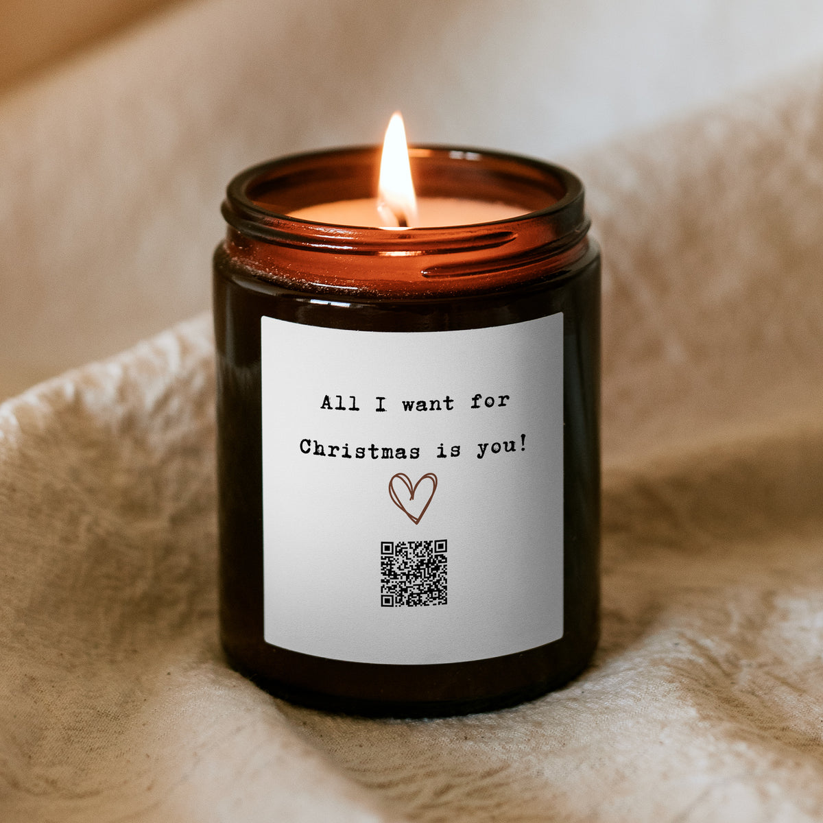 Hořící vánoční svíčka „Melodická“ Kiskedves, na etiketě kreslené srdce, QR kód a nápis All I want for Christmas is you