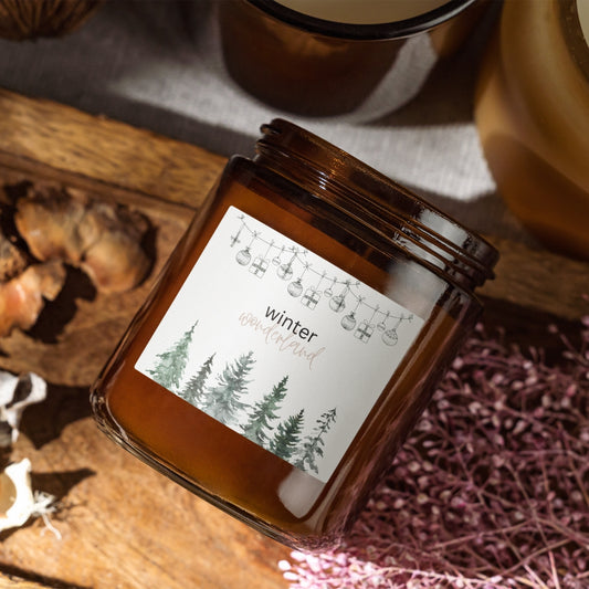 Svíčka Kiskedves Winter Wonderland v hnědé sklenici s akvarelovým štítkem s lesem, na dřevěném tácu.